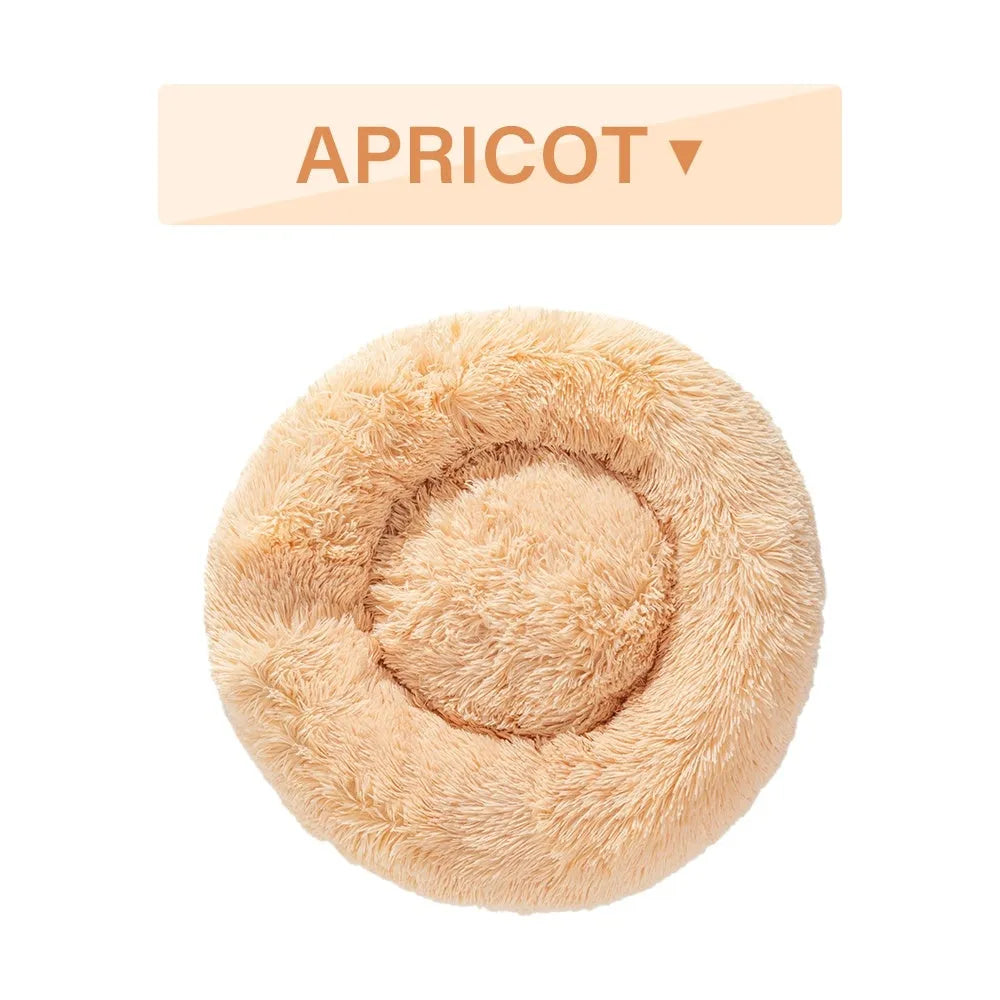 A fluffy, round donut-shaped dog bed with a raised rim in long plush fabric.