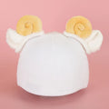 Plush cartoon character decoration sitting on top of a blue ski helmet for customisation.