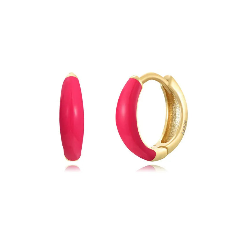 A pair of glossy light green epoxy oval earrings with a U-shaped curve and silver-coloured post on a grey background.