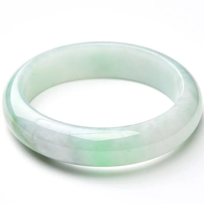 Light green jade bracelet on a wrist, showing its natural stone texture and colour.