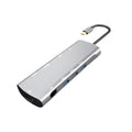 Grey aluminium USBC docking station with HDMI, VGA, USB ports and a short attached cable on a wooden desk