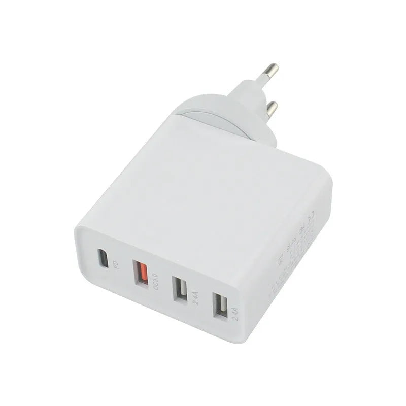Black 48W desktop charger with four USB-C ports and a white UK plug on a wooden table.