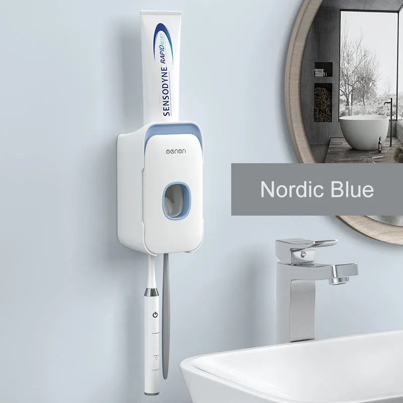Automatic toothpaste dispenser in grey, blue, and pink colours on a bathroom countertop.