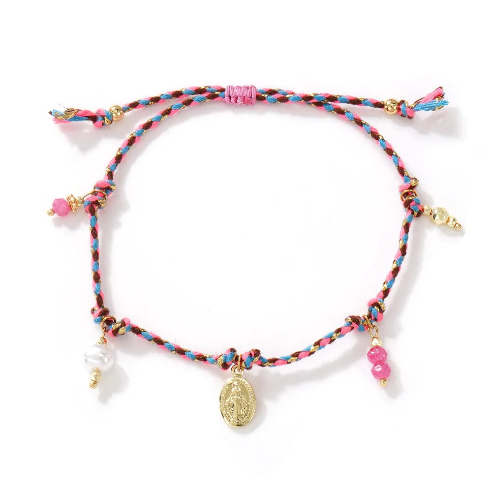 Close-up of a colourful hand-woven adjustable bracelet with an ethnic-style strap tag on a wrist.