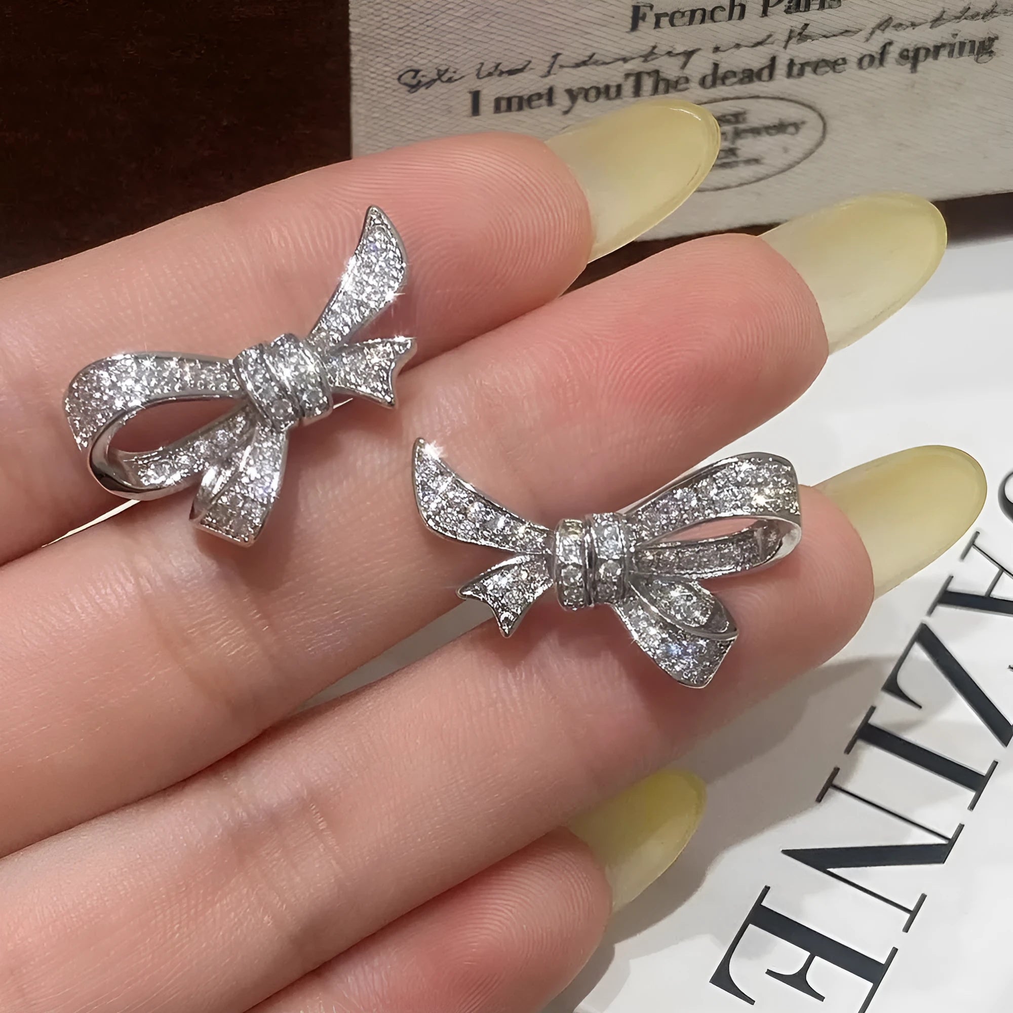 Gold miniature zircon inlaid bowknot ear stud and matching ring set on display