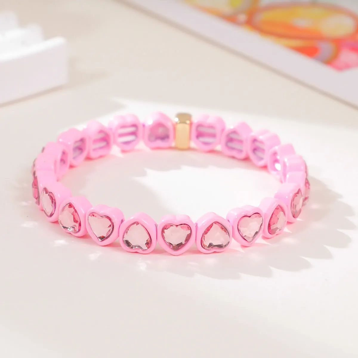 Rainbow enamel heart charm bracelet on alloy base with diamond treatment, stretch band, multicolour design.