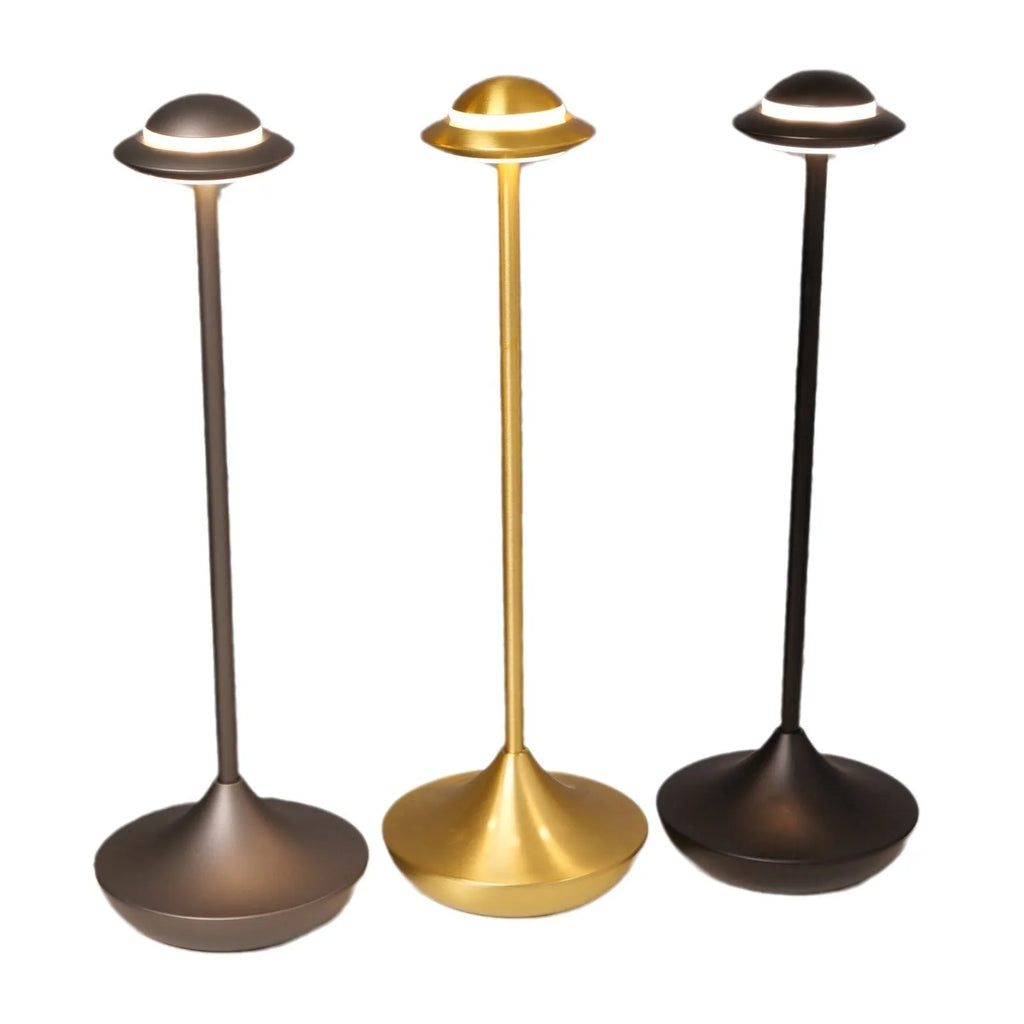 Modern UFO-shaped metal table lamp in black on a wooden desk, showing touch controls and soft glow.