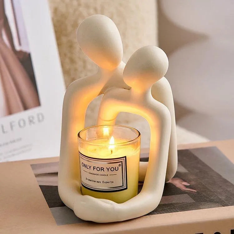 Modern minimalist loving couple resin statue on a shelf in a gold finish.