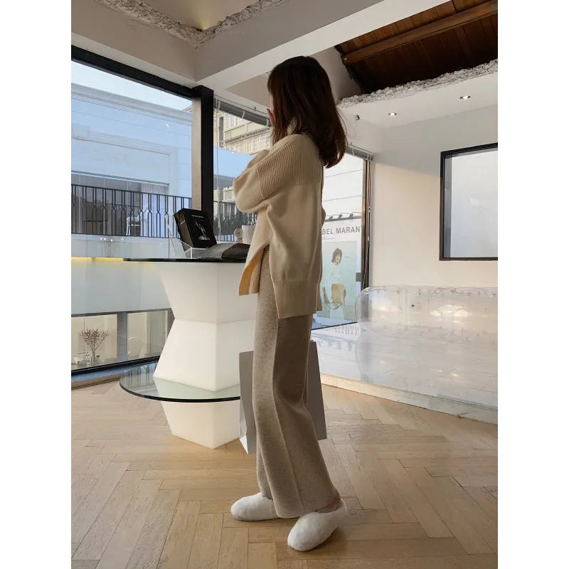 Women's cream white high-waisted wide-leg knitted trousers with a straight leg and drooping hem.