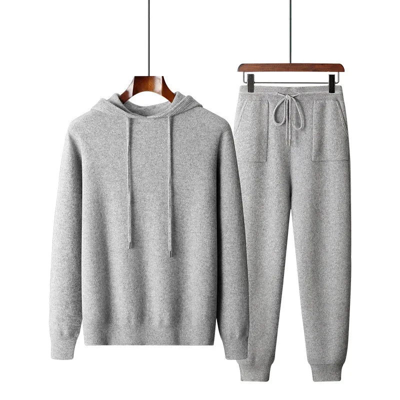 Men's dark grey cashmere hoodie and matching trousers laid out as a complete casual set.