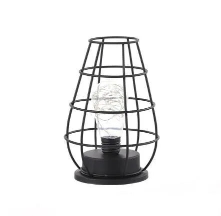 Minimalist hollow iron table lamp with warm white light on a wooden desk