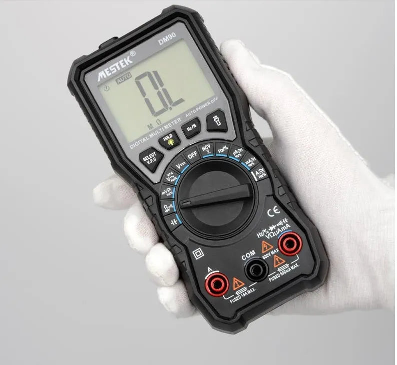 DM90A digital multimeter with test leads on a workbench, showing its display and temperature probe