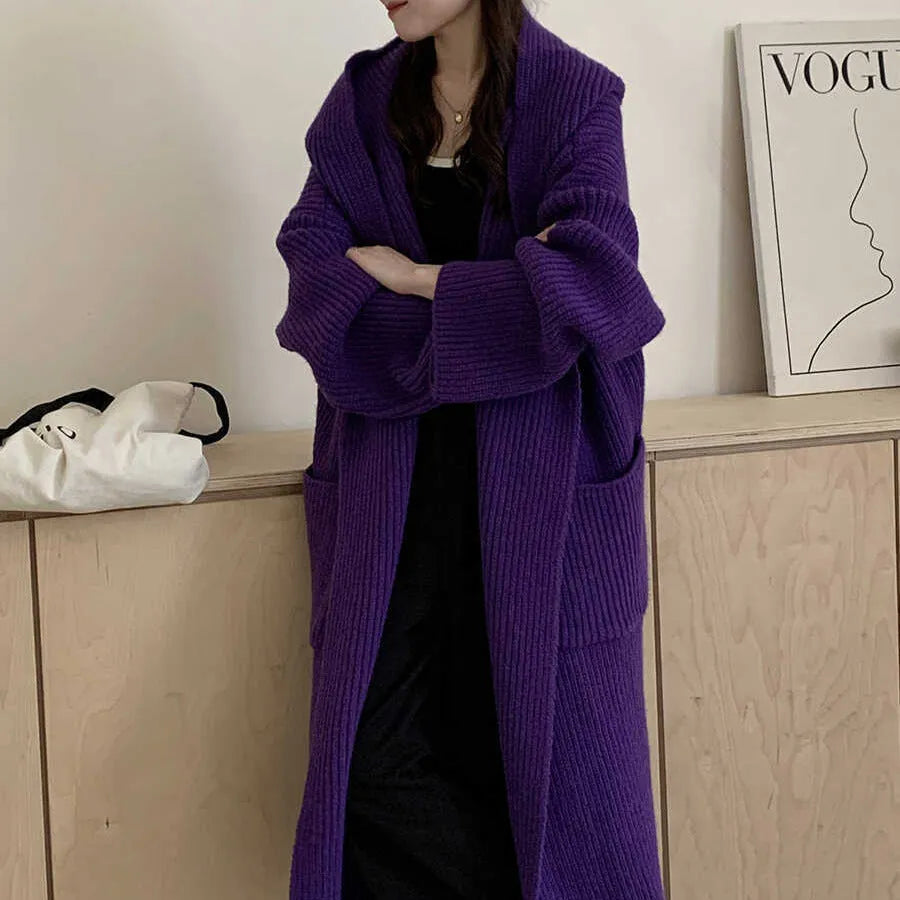 Women's loose grey hooded cardigan coat with raglan sleeves on a hanger.