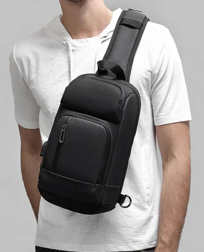Black square vertical PVC shoulder bag showing organiser pockets and air cushion strap.