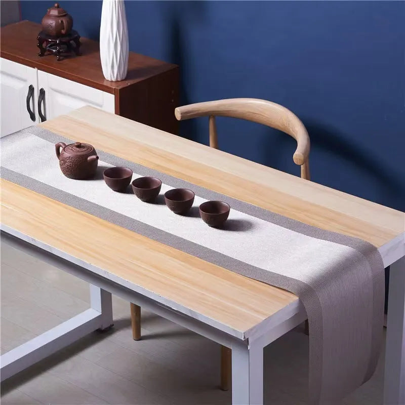 Modern non-slip PVC dish mat with gradient bamboo pattern in black, placed on a wooden dining table.