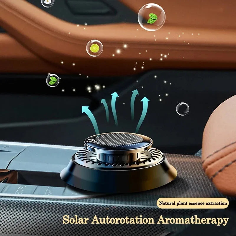 Solar-powered kinetic car air freshener with two rotating black rings on a plastic base.
