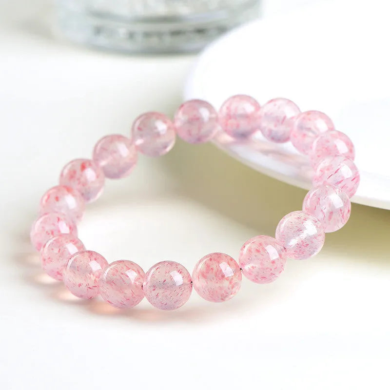 Geometric strawberry quartz crystal beads bracelet in natural white water colour on a wrist.