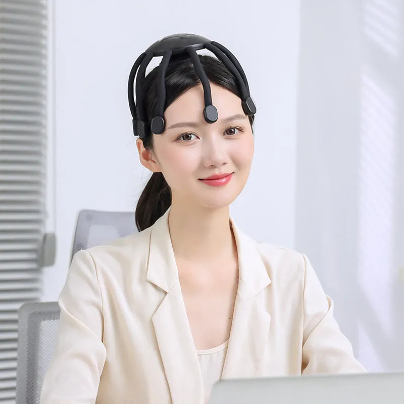 Black handheld head massager with eight extending claws showing silicone tips and control button