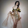 Gold strapless sequin evening dress with a long tulle skirt and thigh split on a mannequin.