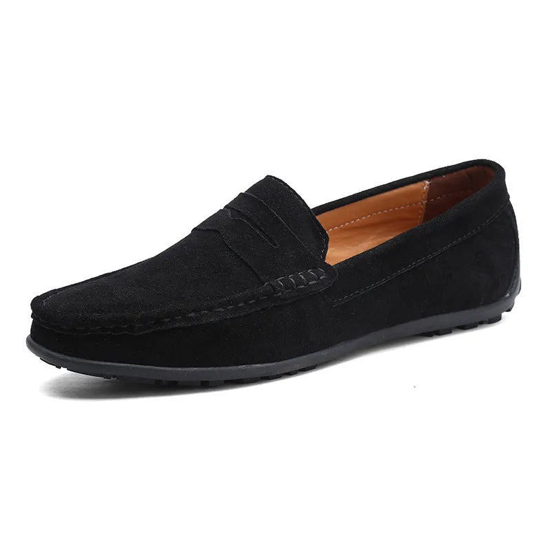 Men's suede leather Gommino loafers in black on a flat rubber sole, showing round toe and sewing line detail.