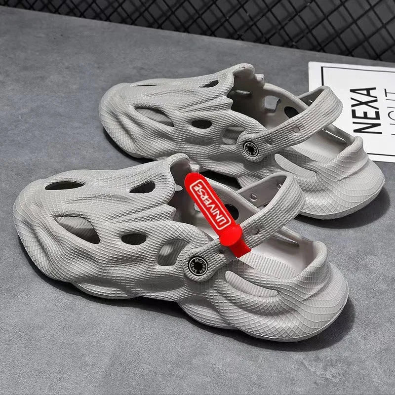 Men's grey EVA foam slippers with closed toe and thickened sole on a sandy beach.