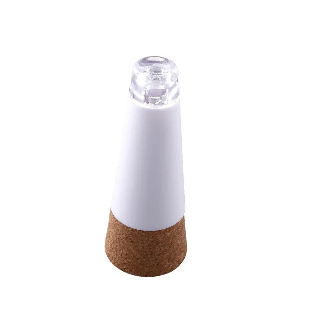 White plastic USB-rechargeable LED bottle cap cork light with micro-USB port, shown next to a whisky bottle.