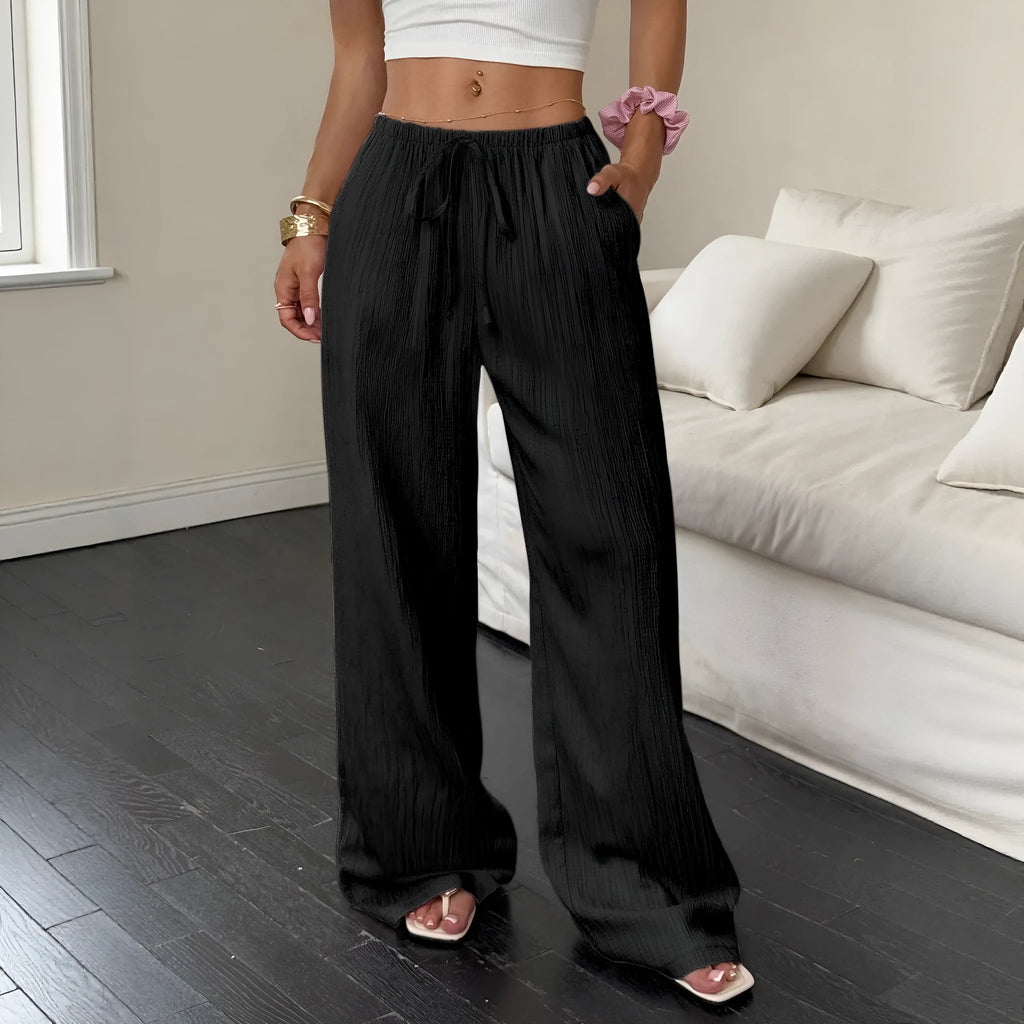 Black wide-leg women's trousers with a front lace-up waist detail on a neutral background.