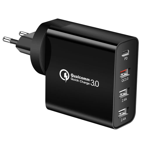 Black 48W desktop charger with four USB-C ports and a white UK plug on a wooden table.