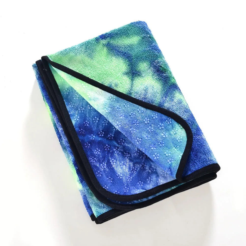 Tie-dyed blue microfiber non-slip yoga mat towel measuring 63x183cm on a yoga mat