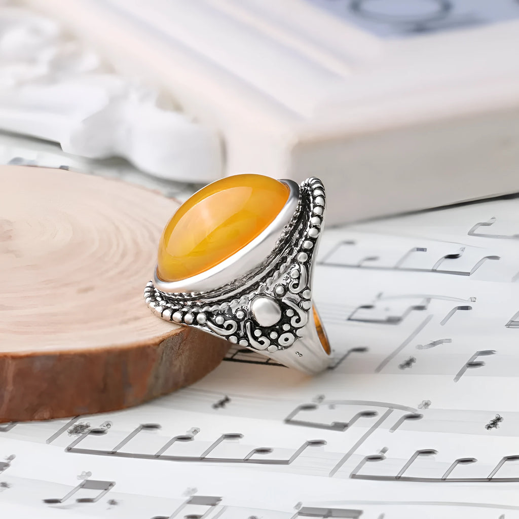 Geometric retro ring in antique silver amber colour on a grey background.