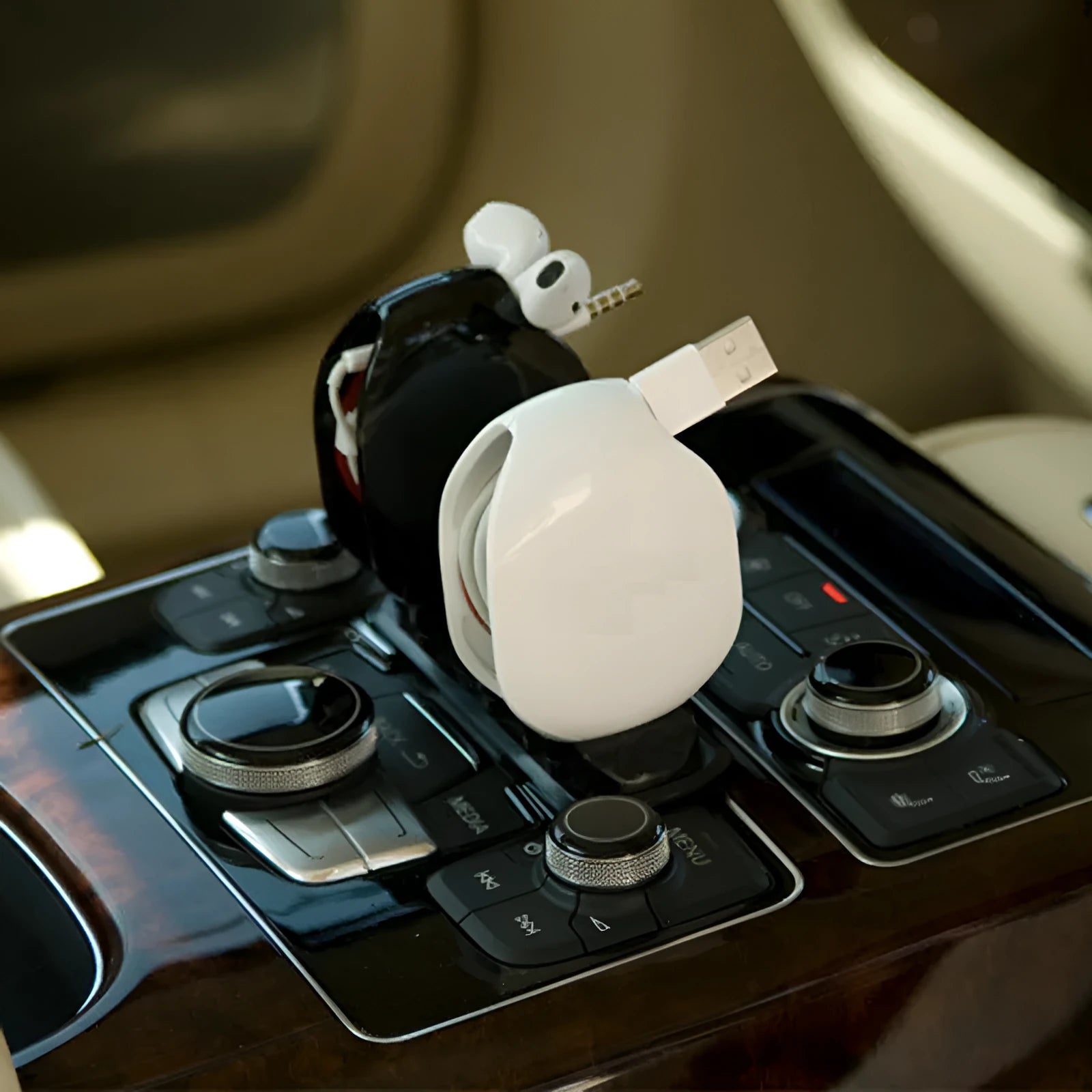 Automatic earphone cable winder retractor in blue, showing compact size next to a 3.5mm jack.