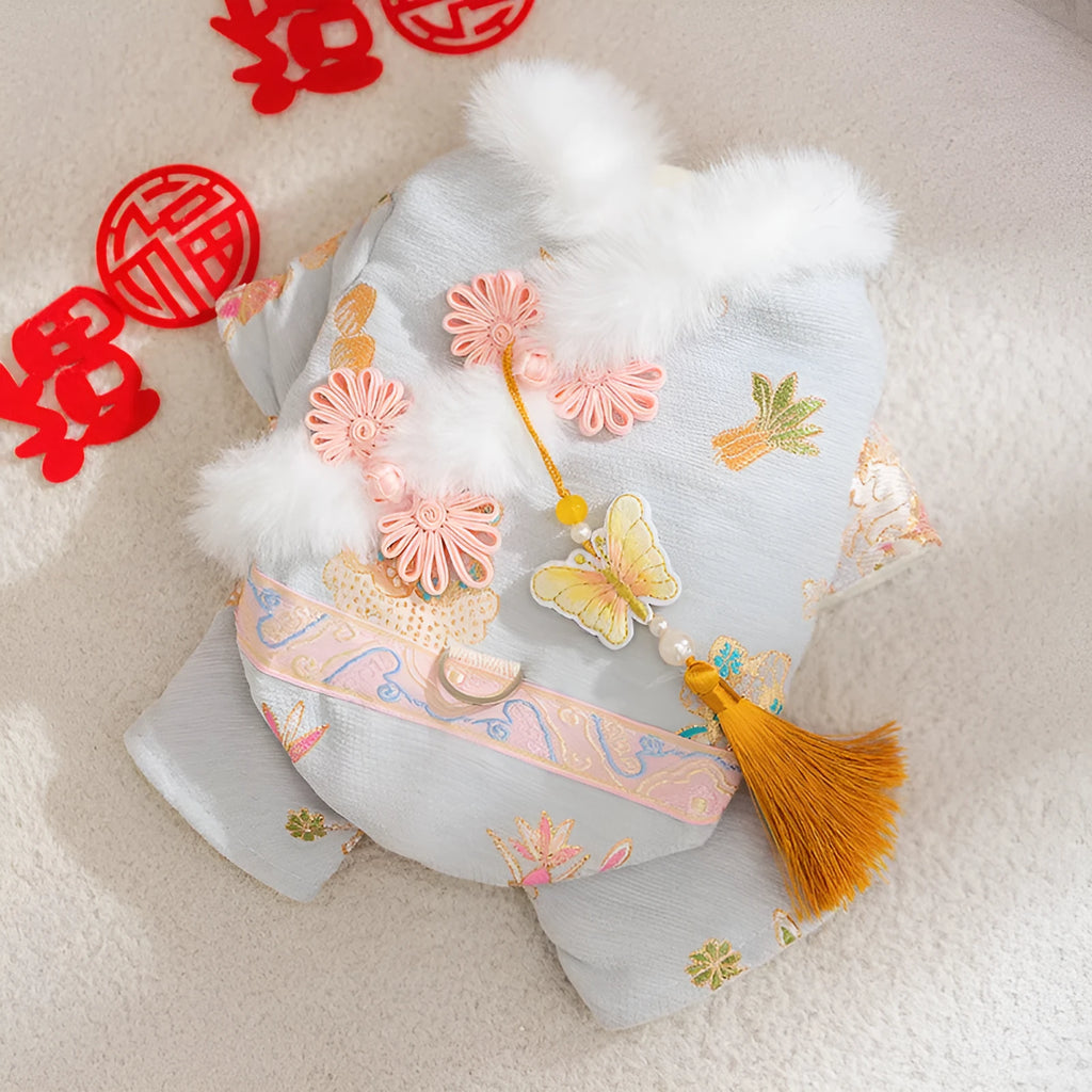 Light blue cheongsam pet coat with embroidered floral motifs, butterfly ornament, golden tassel, faux fur trim, and metal leash ring