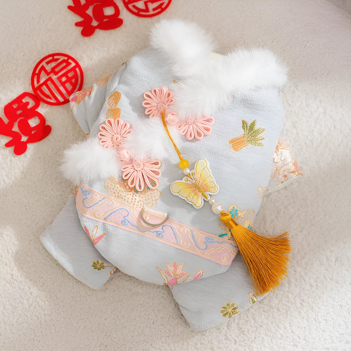 Light blue cheongsam pet coat with embroidered floral motifs, butterfly ornament, golden tassel, faux fur trim, and metal leash ring