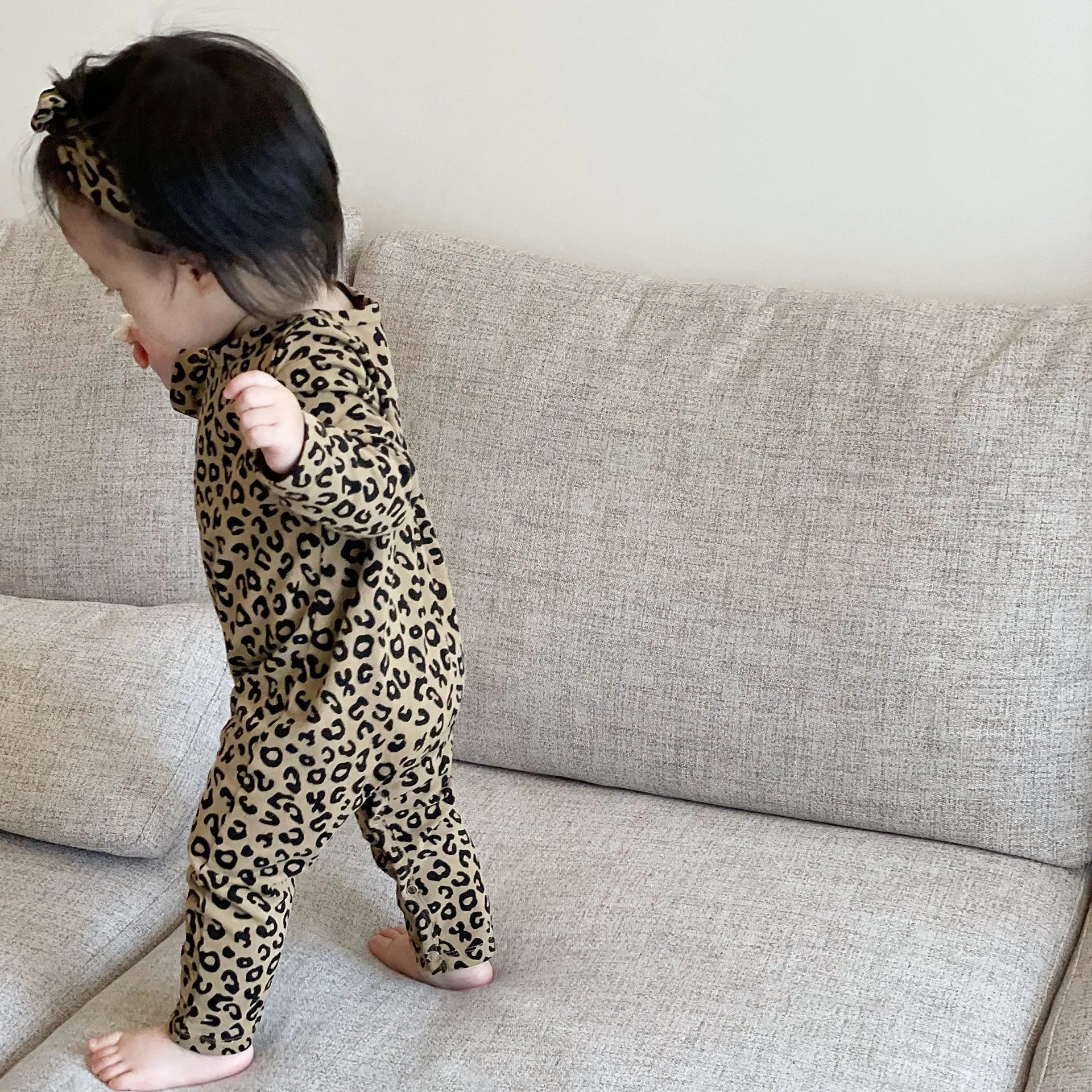 Brown leopard print cotton long-sleeved baby jumpsuit with matching headband, neutral unisex style