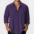 Man wearing a solid colour loose-fit long sleeve shirt with a stand collar.