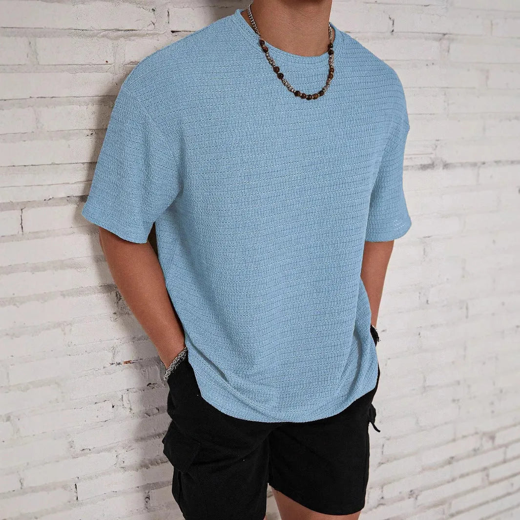Men's loose slim fit solid colour short sleeve T-shirt in light blue on a grey background.