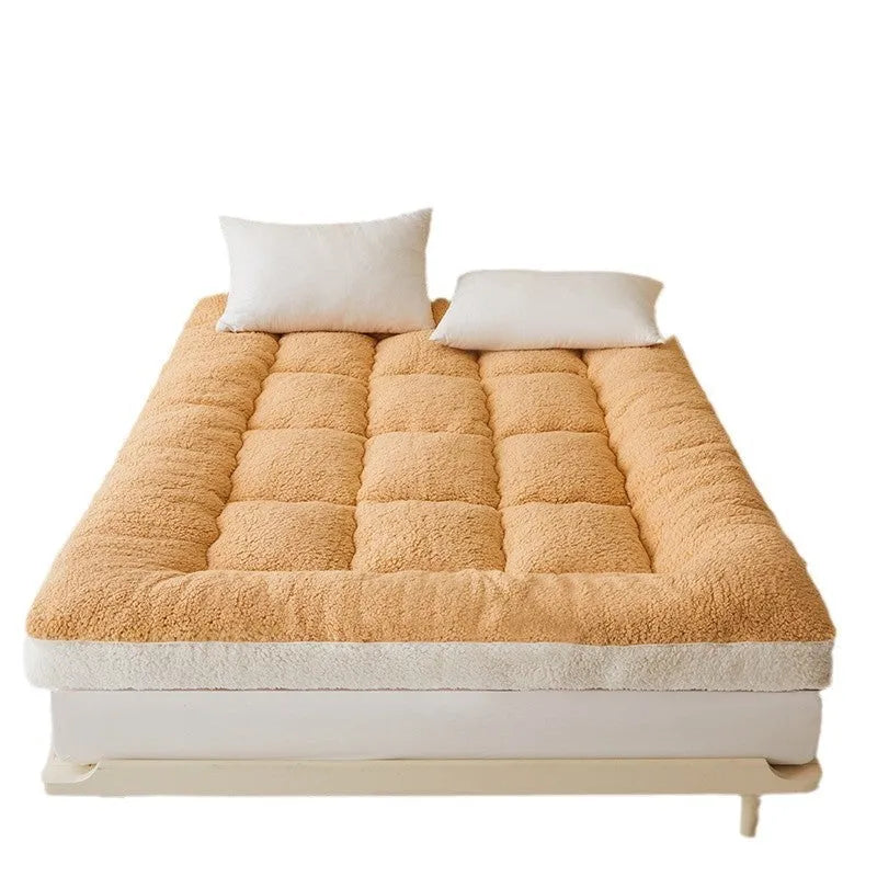 Lambswool mattress cushion with velvet cover in grey and white edge, on a bed