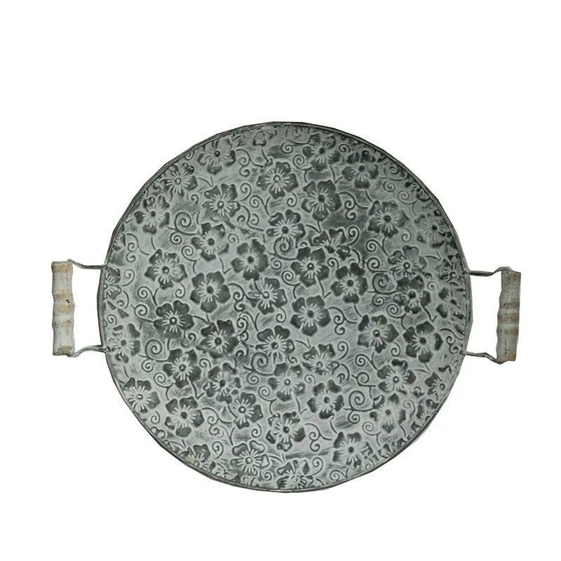Round wrought iron belt storage tray set in two sizes on a wooden table.
