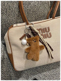 Brown plush bear pendant keychain attached to a bag, soft toy decoration