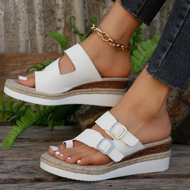 White patent leather women's wedge sandals with finger fit straps and woven detail, peep toe.