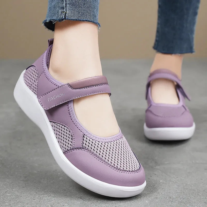 Women's low-top grey mesh casual trainers with Velcro fastening and a flat polyurethane sole.