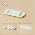 Blue high-capacity ice cube tray with silicone lid and ice scoop stored in its dedicated slot.