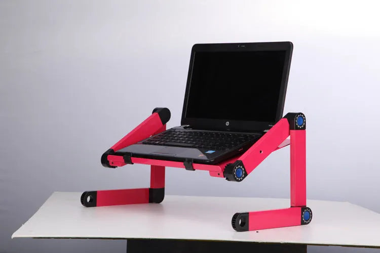 Black folding laptop table stand with six legs, magnesium alloy desktop, and attached mouse pad, folded view on a desk