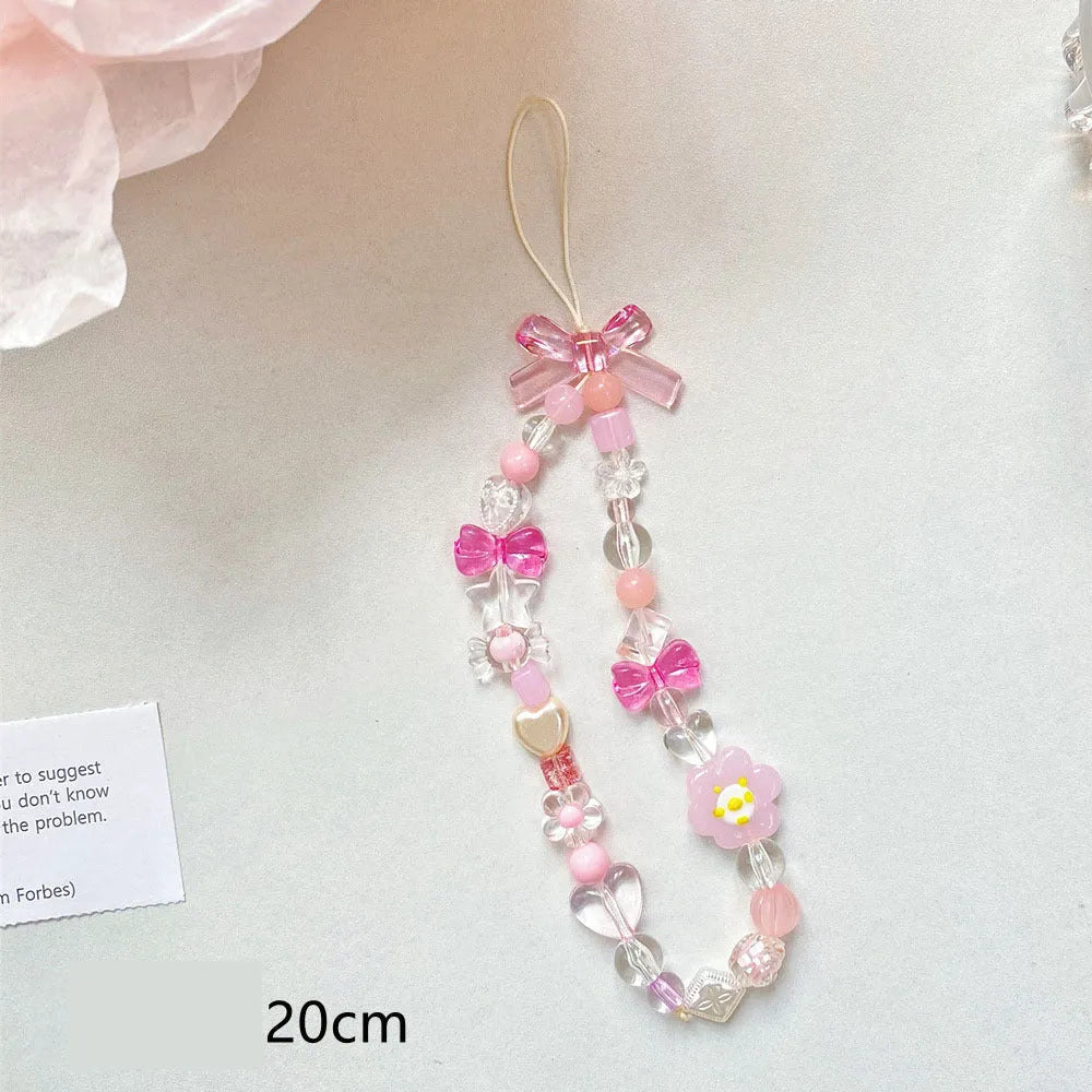 Yellow, blue, and pink beaded flower phone lanyard on a hand rope.