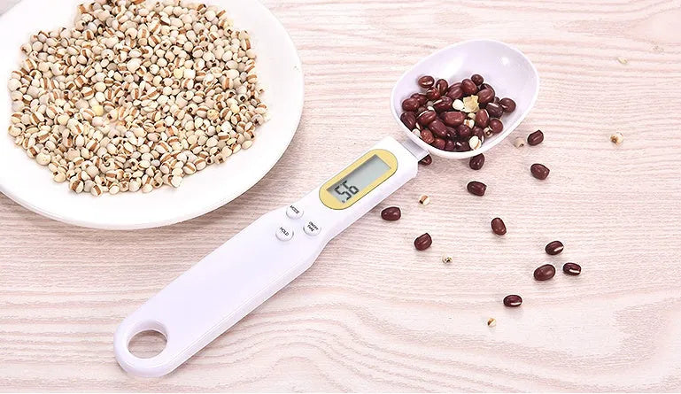 Black electronic measuring spoon scale with digital display showing weight measurement