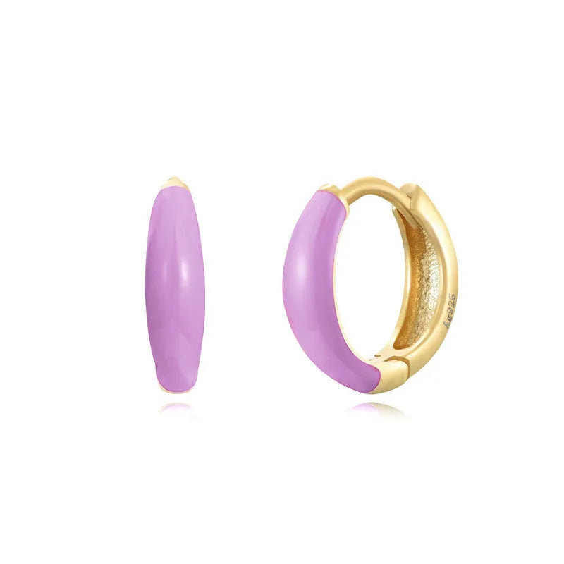 A pair of glossy light green epoxy oval earrings with a U-shaped curve and silver-coloured post on a grey background.