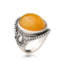 Geometric retro ring in antique silver amber colour on a grey background.