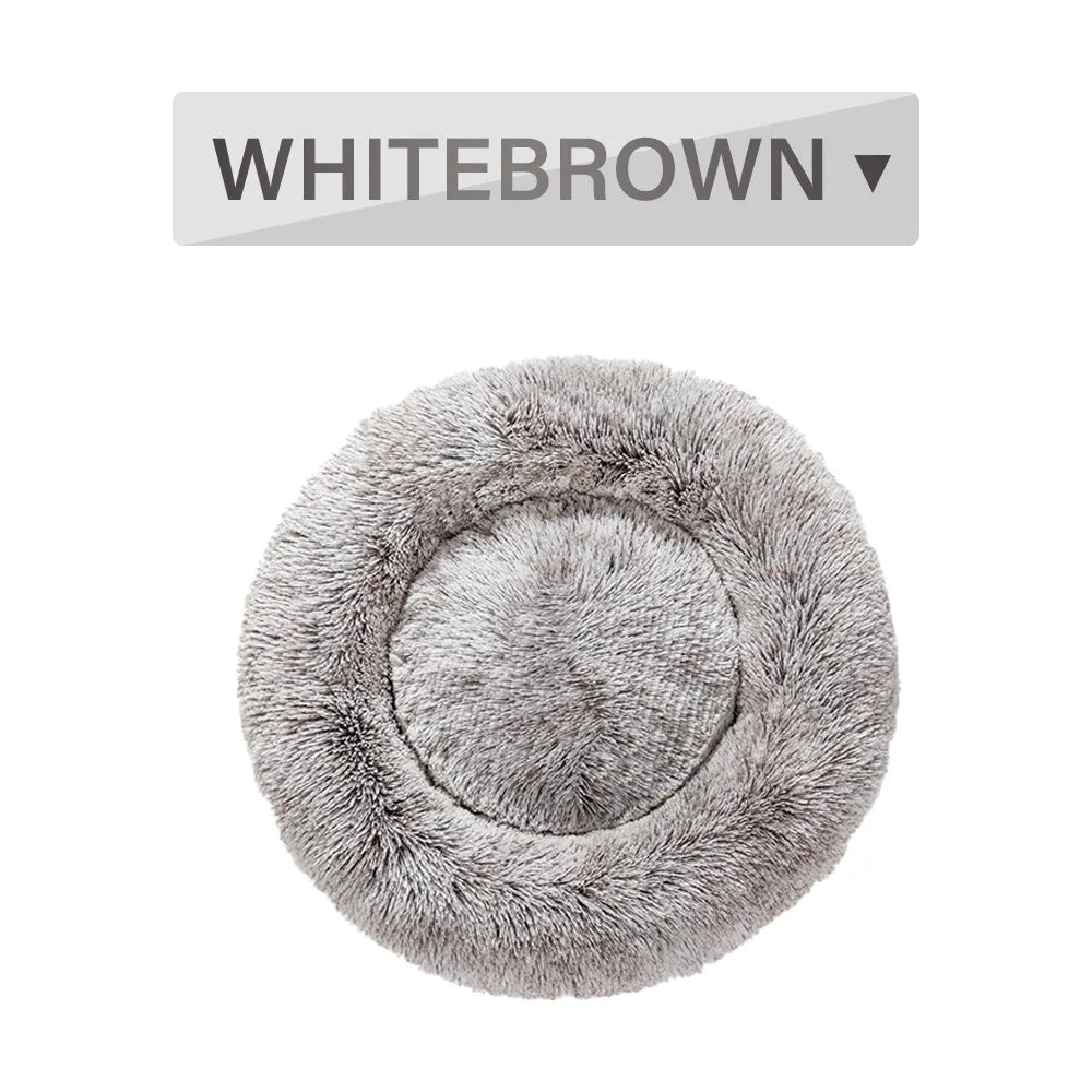 A fluffy, round donut-shaped dog bed with a raised rim in long plush fabric.
