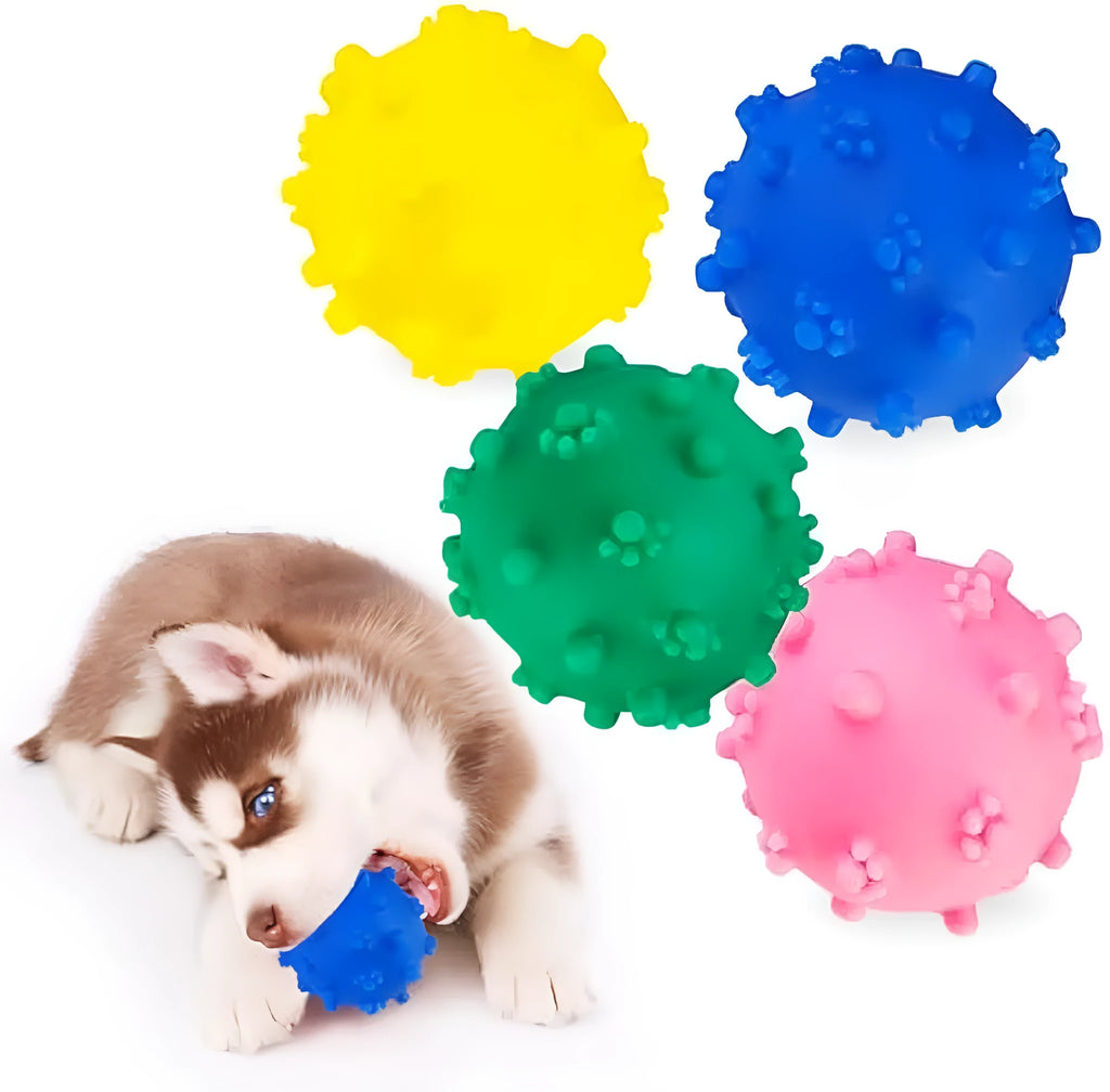 Bright blue, green, pink, and yellow spiked squeaky dog toy balls on a grass lawn.
