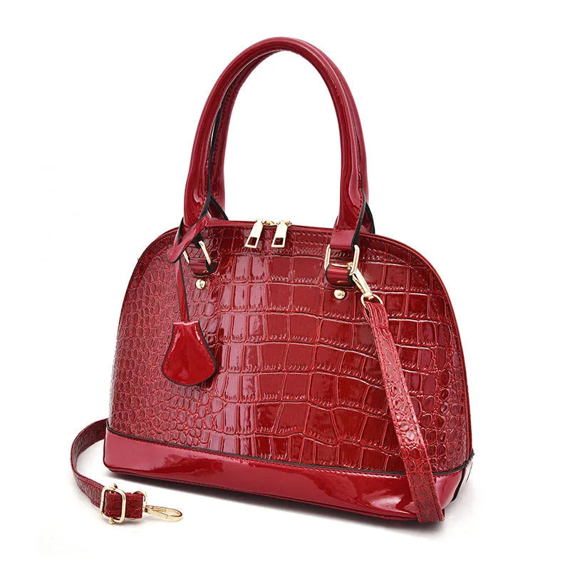 Shiny black PU shoulder bag with crossbody strap showing shell-shaped structure
